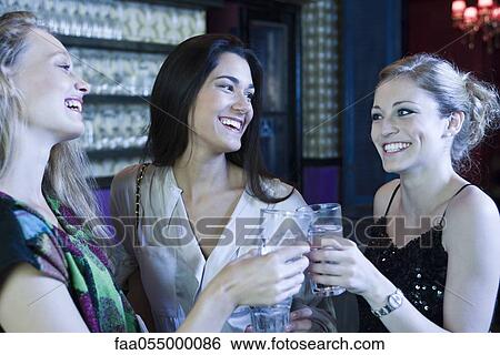 Stock Photograph - Friends celebrating together in bar. Fotosearch
