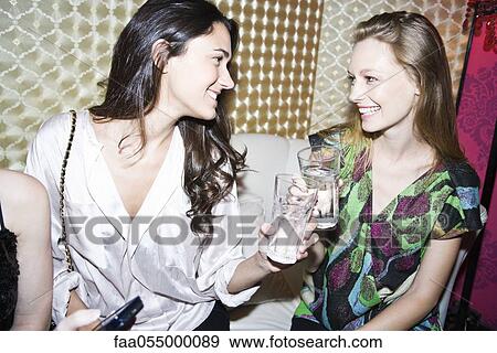 Friends chatting together at nightclub View Large Photo Image Stock Photo - Friends chatting together at nightclub. Fotosearch