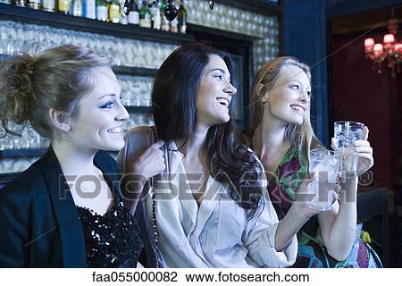 Friends having drinks together at bar View Large Photo Image Stock Image - Friends having drinks together at bar. Fotosearch