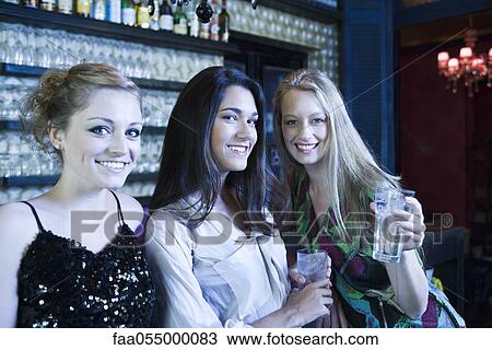 Friends having drinks together at bar View Large Photo Image Stock Image - Friends having drinks together at bar. Fotosearch