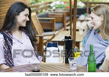 Stock Photo - Friends relaxing together at cafe. Fotosearch