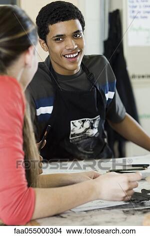High school student chatting with classmate in art class View Large Photo Image Picture - High school student chatting with classmate in art class. Fotosearch