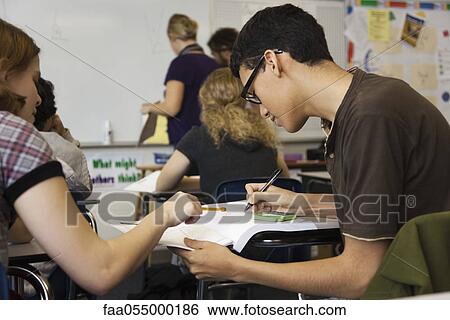 High school student helping classmate with assignment View Large Photo Image Stock Photograph - High school student helping classmate with assignment. Fotosearch