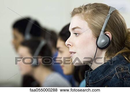 High school students listening to headphones, profile View Large Photo Image Stock Photo - High school students listening to headphones, profile. Fotosearch