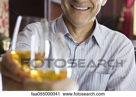 Man clinking glasses with companion in restaurant View Large Photo Image Stock Image - Man clinking glasses with companion in restaurant. Fotosearch