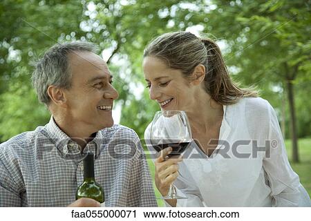 Mature couple enjoying red wine outdoors View Large Photo Image Stock Image - Mature couple enjoying red wine outdoors. Fotosearch