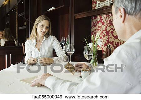 Mature couple having coffee in restaurant, man preparing to pay with credit card View Large Photo Image Stock Photo - Mature couple having coffee in restaurant, man preparing to pay with credit card. Fotosearch