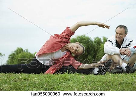 Mature couple stretching in park View Large Photo Image Stock Image - Mature couple stretching in park. Fotosearch