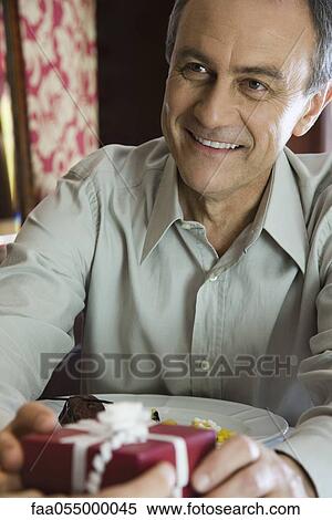 Mature man giving woman gift, cropped View Large Photo Image Stock Photography - Mature man giving woman gift, cropped. Fotosearch