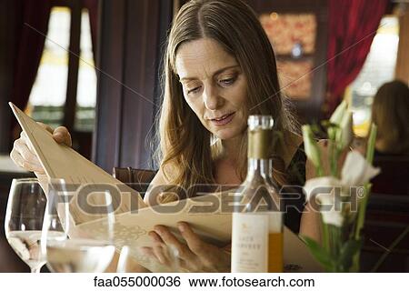 Mature woman looking at menu in restaurant View Large Photo Image Stock Photograph - Mature woman looking at menu in restaurant. Fotosearch