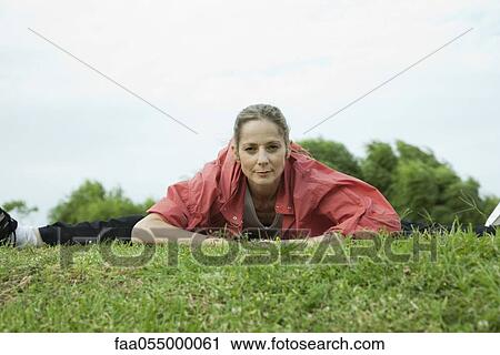 Stock Image - Mature woman stretching in park. Fotosearch