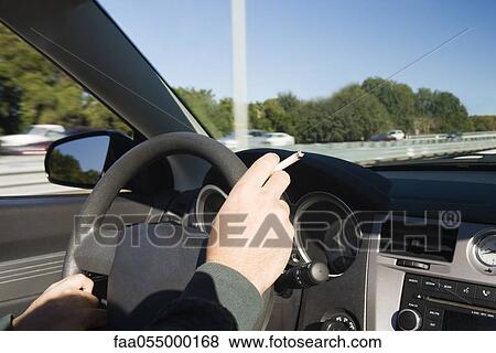 Smoking a cigarette while driving View Large Photo Image Stock Photo - Smoking a cigarette while driving. Fotosearch