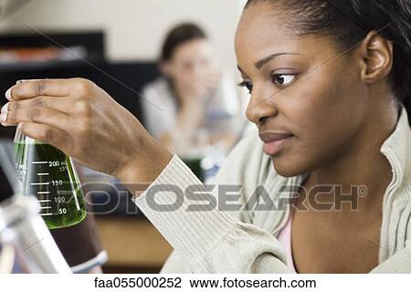 Stock Image - Student conducting experiment in chemistry class. Fotosearch