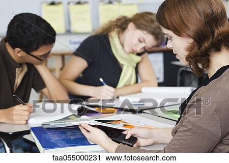 Student looking at cell phone during class View Large Photo Image Stock Image - Student looking at cell phone during class. Fotosearch