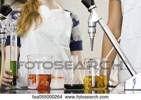 Picture - Students conducting experiment in chemistry class, cropped. Fotosearch