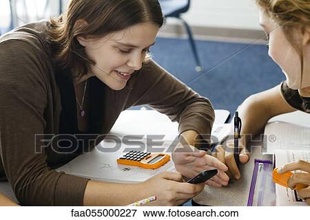 Stock Photo - Students looking at cell phone in class. Fotosearch