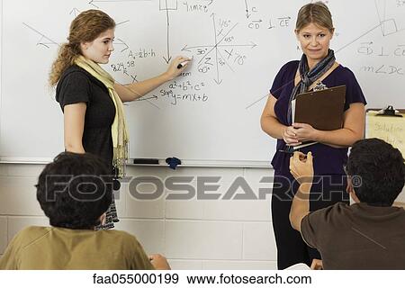 Stock Photo - Teacher explaining mathematics to students in classroom. Fotosearch