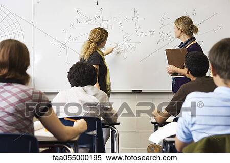 Teacher helping student with mathematic equation written on whiteboard View Large Photo Image Stock Photography - Teacher helping student with mathematic equation written on whiteboard. Fotosearch