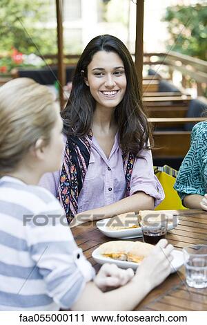 Young woman having lunch with friend View Large Photo Image Stock Image - Young woman having lunch with friend. Fotosearch
