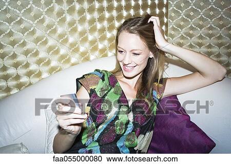 Stock Image - Young woman text messaging. Fotosearch