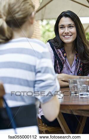 Young woman with friend at cafe View Large Photo Image Stock Image - Young woman with friend at cafe. Fotosearch