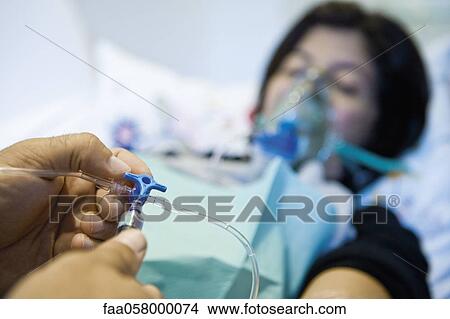Doctor adjusting patient's IV drip, cropped View Large Photo Image Picture - Doctor adjusting patient's IV drip, cropped. Fotosearch