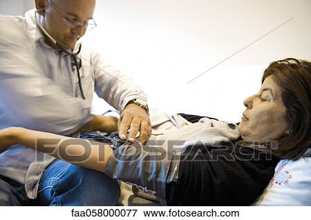 Doctor checking patient's blood pressure View Large Photo Image Stock Photo - Doctor checking patient's blood pressure. Fotosearch