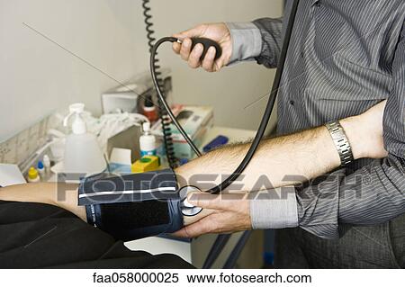 Doctor checking patient's blood pressure View Large Photo Image Stock Photography - Doctor checking patient's blood pressure. Fotosearch
