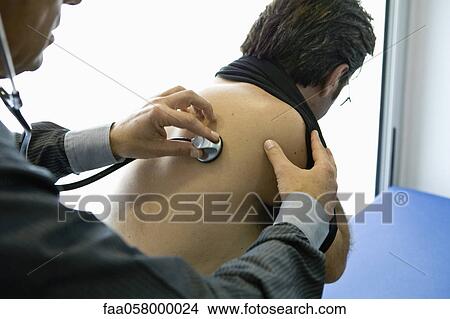 Doctor listening to patient's back with stethoscope View Large Photo Image Picture - Doctor listening to patient's back with stethoscope. Fotosearch