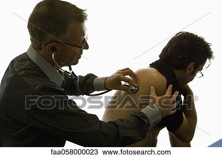 Doctor listening to patient's back with stethoscope View Large Photo Image Stock Image - Doctor listening to patient's back with stethoscope. Fotosearch
