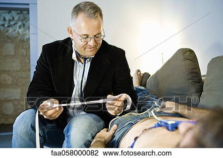 Doctor performing portable EKG (electrocardiogram) on patient in home View Large Photo Image Stock Image - Doctor performing portable EKG (electrocardiogram) on patient in home. Fotosearch
