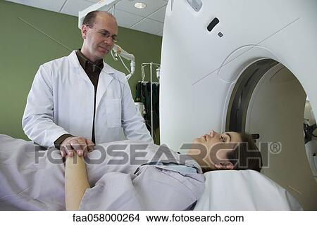 Doctor reassuring female patient preparing to undergo CAT scan View Large Photo Image Picture - Doctor reassuring female patient preparing to undergo CAT scan. Fotosearch