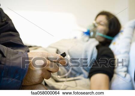 Doctor treating patient in home, cropped View Large Photo Image Picture - Doctor treating patient in home, cropped. Fotosearch