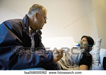 Emergency on-call doctor administering oxygen to patient in home View Large Photo Image Stock Image - Emergency on-call doctor administering oxygen to patient in home. Fotosearch