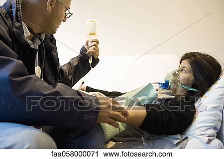 Emergency on-call doctor treating patient in home View Large Photo Image Stock Image - Emergency on-call doctor treating patient in home. Fotosearch