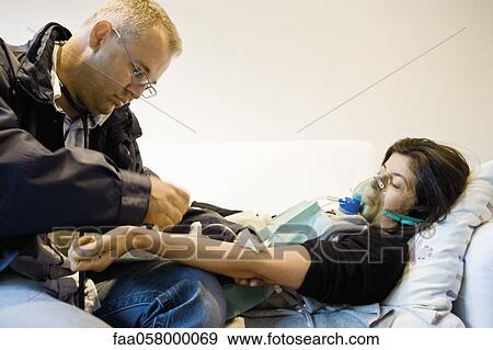 Emergency on-call doctor treating patient in home View Large Photo Image Stock Photo - Emergency on-call doctor treating patient in home. Fotosearch