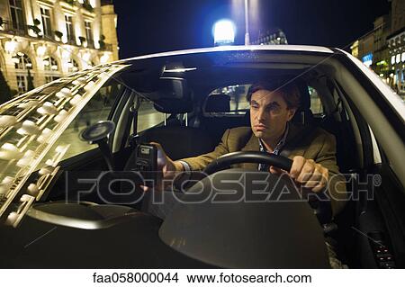 Emergency on-call doctor using GPS to navigate his way to a house call at night View Large Photo Image Picture - Emergency on-call doctor using GPS to navigate his way to a house call at night. Fotosearch