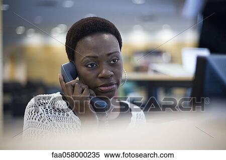 Female office worker talking on phone View Large Photo Image Stock Photography - Female office worker talking on phone. Fotosearch