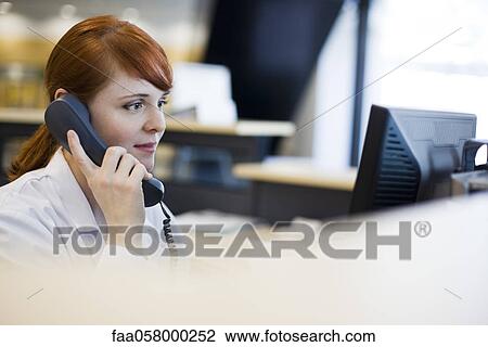 Female receptionist talking on phone View Large Photo Image Stock Image - Female receptionist talking on phone. Fotosearch