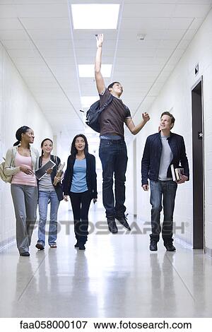 High school students in school corridor watching friend jumping View Large Photo Image Stock Photo - High school students in school corridor watching friend jumping. Fotosearch