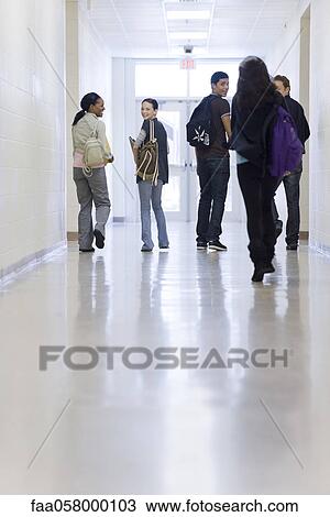 Stock Image - High school students walking down school corridor. Fotosearch