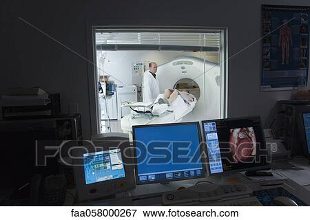 Male doctor standing next to female patient having CAT scan View Large Photo Image Stock Photo - Male doctor standing next to female patient having CAT scan. Fotosearch