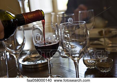 Stock Image - Pouring glass of red wine. Fotosearch