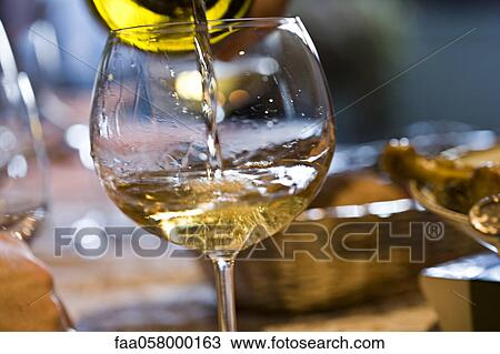 Pouring glass of white wine View Large Photo Image Stock Image - Pouring glass of white wine. Fotosearch