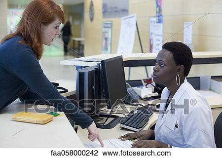 Upset patient explaining problem to medical receptionist View Large Photo Image Stock Image - Upset patient explaining problem to medical receptionist. Fotosearch