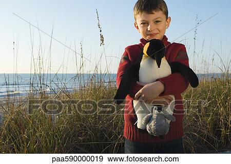 Boy outdoors holding stuffed toy penguin View Large Photo Image Stock Photo - Boy outdoors holding stuffed toy penguin. Fotosearch