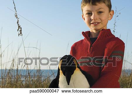 Boy outdoors holding stuffed toy penguin View Large Photo Image Stock Photo - Boy outdoors holding stuffed toy penguin. Fotosearch
