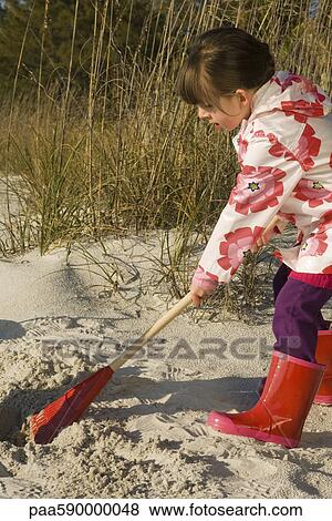 Stock Photo - Girl raking sand. Fotosearch
