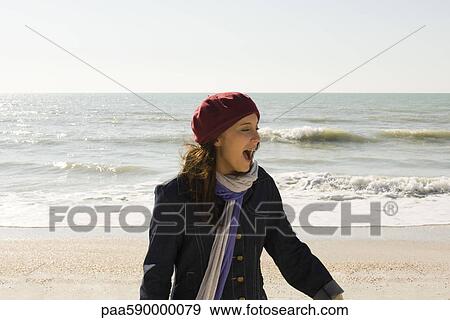 Stock Photo - Preteen girl at beach on winter's day. Fotosearch