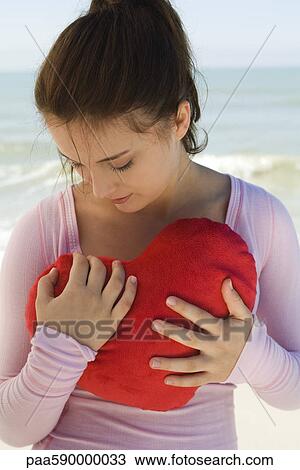 Preteen girl holding heart-shaped stuffed toy View Large Photo Image Stock Image - Preteen girl holding heart-shaped stuffed toy. Fotosearch
